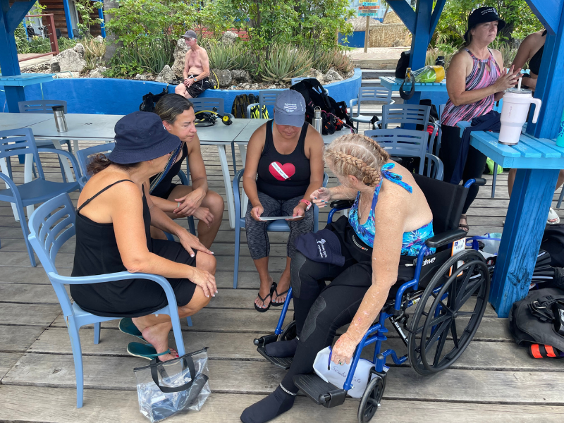 volunteer dive buddies and adaptive diver preparing for a dive